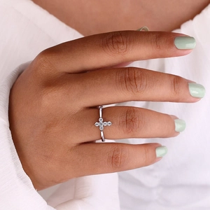 Macro detail of silver cross ring with micro-pave zircons on a model's finger