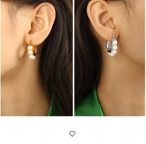 Close-up of elegant gold and silver hoop earrings featuring four lustrous white pearls