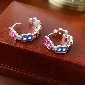 Letter B hoop earrings with pink and blue enamel and zircon inlay on a leather box