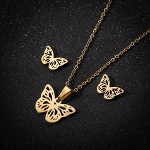 Set di gioielli con farfalla dorata con collana e orecchini a lobo su uno sfondo nero