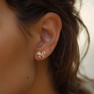 Detailed macro shot of a delicate colorful butterfly stud earring worn on an earlobe
