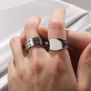 Industrial punk silver stainless steel rings for men shown on fingers with fabric backdrop
