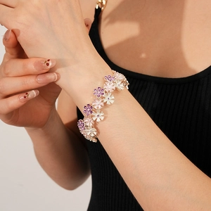 Detailaufnahme eines bunten Emaille-Blumenarmbands mit lila und rosa Blütenblättern