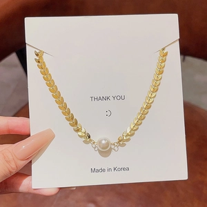 Baroque pearl necklace with gold leaf chain design on white display card