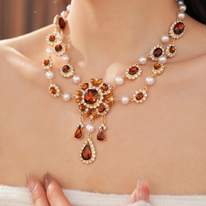 Nahaufnahme einer Vintage-Goldhalskette mit Bernstein und Perlen am Modellhals