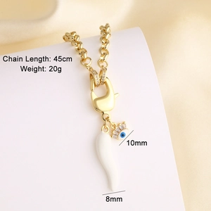 Macro view of gold chain necklace with evil eye and white horn pendant, 45cm length
