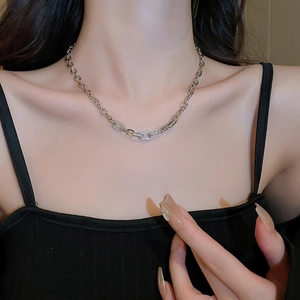 Silver geometric link chain necklace with zircon embellishment worn by a model