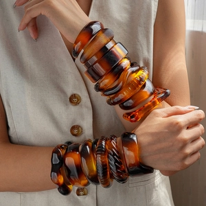 Amber resin acrylic bangle set with geometric irregular shapes on model's wrist