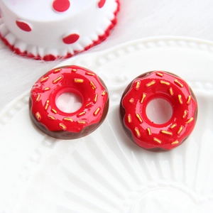 Macro shot of two glossy red resin donuts with yellow sprinkles for DIY crafts