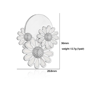 White enamel daisy stud earrings with silver edges and sparkling center rhinestone