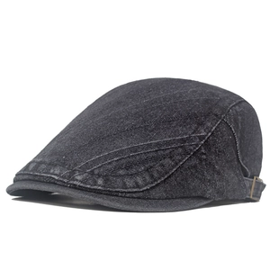 Dettaglio del berretto in denim nero lavato con cuciture e fibbia in ottone regolabile