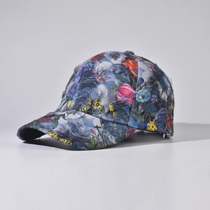 Detail of a denim baseball cap featuring colorful floral patterns and butterfly embroidery