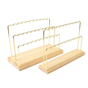Three-tier gold metal jewelry display stand with a natural solid wood base for earrings