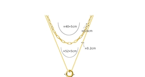 Detail view of double-layer gold necklaces with paperclip chain and interlocking ring pendant