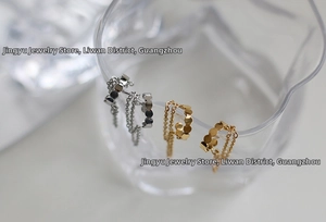 Macro detail of gold and silver steel fringe tassel earrings on glass rim