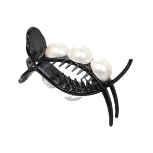 Pince à cheveux noire élégante avec trois grandes perles blanches sur fond blanc
