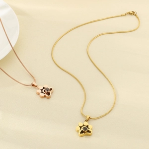 Détail de pendentifs patte en or rose et or avec pierres de projection sur chaînes