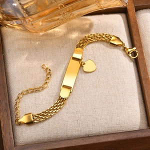 Polished gold mesh bracelet with engravable blank plate and delicate heart pendant detail