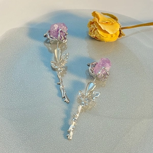 Detail von silbernen langen Ohrhängern mit lila Amethysten und floralem Rosendesign