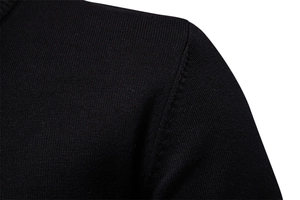 Gros plan de la couture d'épaule du pull noir montrant la texture du tricot