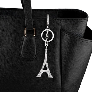 Détail d'un porte-clés Tour Eiffel argenté avec strass accroché à un sac à main noir