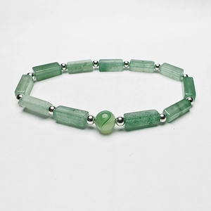 Macro shot of rectangular green natural stone beads and silver spiral bead on bracelet