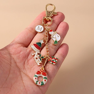 Detail of Christmas keychain with enamel snowman, tree, wreath, and NOEL charms