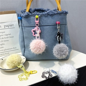 Colorful plush flower ball keychain accessories with acrylic chain on stylish denim bag