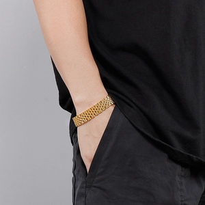 Close-up of golden stainless steel jubilee watch-band style bracelet on a wrist