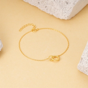 Detail of interlocking smooth and twisted gold rings on an S925 silver chain