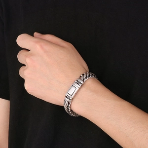 Macro detail of men's vintage silver stainless steel braided chain bracelet on wrist