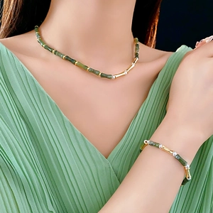 Detail of green bamboo style jade necklace and bracelet with gold metal accents