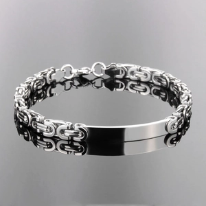 Macro shot of polished silver stainless steel bracelet with engravable curved bar plate