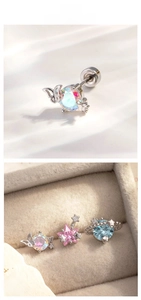 Detail of pink star and blue planet stud earrings with iridescent stones in a jewelry box