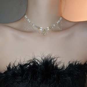 Détail d'un collier multicouche de perles et cristaux avec pendentif cœur doré sur un mannequin