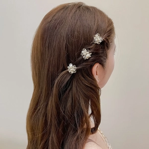 Set of three mini camellia hair clips in champagne pearl finish worn on hair