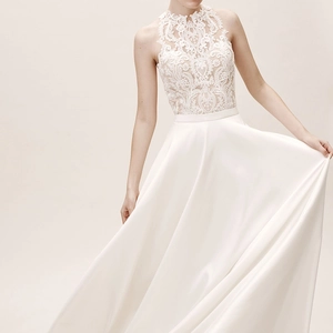 Elegant sleeveless satin bridal gown with floral lace embroidery and a high neckline