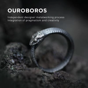 Oxidized 925 sterling silver Ouroboros ring on volcanic stone in a cinematic macro view