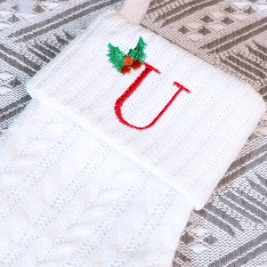 Chaussette de Noël en tricot blanc avec lettre U brodée en rouge et décor de houx