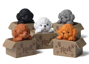 Detail of five miniature resin teddy dog figurines in colorful cardboard boxes