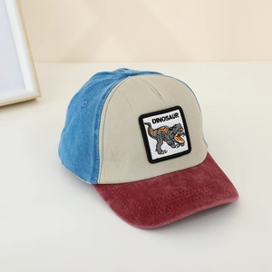 Detail of dinosaur embroidery and corduroy brim on kids patchwork baseball cap