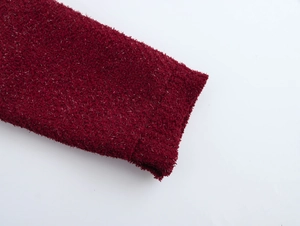Détail de la texture en peluche rouge avec fils argentés scintillants et aspect moelleux
