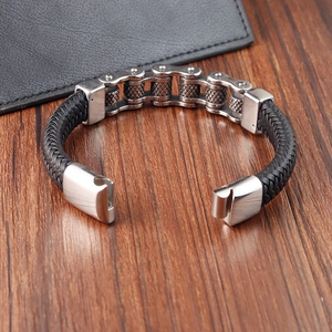 Détail du bracelet en acier inoxydable style chaîne de vélo sur bois et cuir