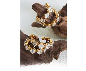 Detail of C-shaped 18K gold plated hoop earrings with square-cut sparkling cubic zirconia
