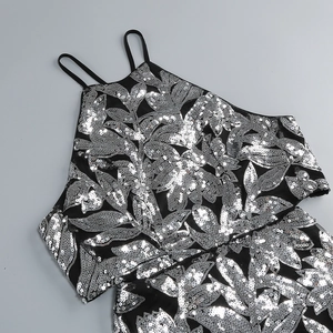 Détail de broderies florales à paillettes argentées sur robe de soirée noire