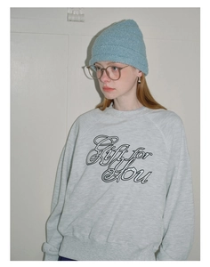 Detailed close-up of light blue knit beanie with ribbed texture worn by female model