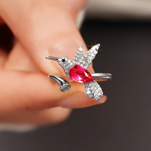 Macro-detail van kolibrie ring met peervormige rode edelsteen en witte zirkonia steentjes