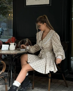 Détail de robe fleurie avec col en V en dentelle et poignets à manches bouffantes