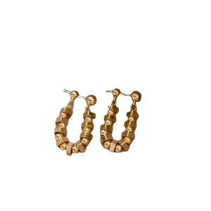 Golden U-shaped earrings featuring polished beads and frosted geometric hexagonal blocks