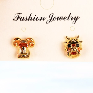 Detailopname van gouden ram- en draakoorbellen op een Fashion Jewelry-kaartje